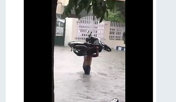 viral-pria-bertelanjang-dada-panggul-motor-di-tengah-banjir